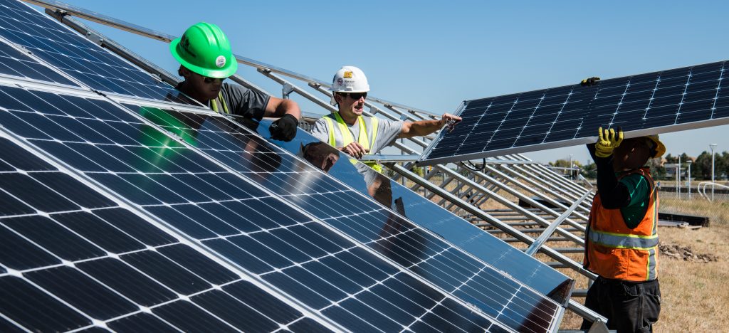 homens instalando painéis solares